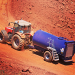 Photo of a tractor pulling a Fuel Proof Site Tow Bowser on a red dirt path